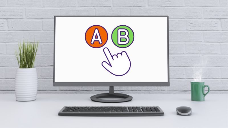 Een beeldscherm op een bureau met een rode letter A en een groene letter B erop, en een muisaanwijzer die kiest