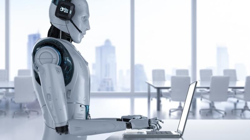 Een robot met koptelefoon typt op een laptop in een leeg kantoor met glazen wanden