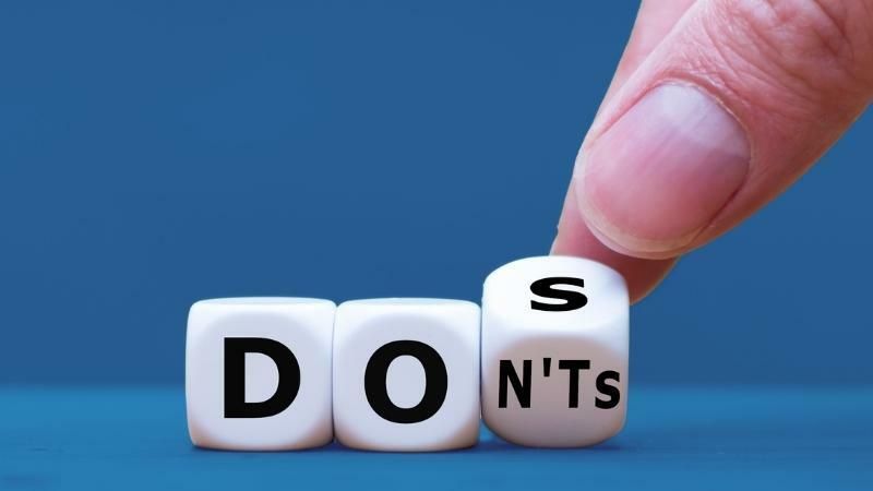 Witte dobbelstenen met de letters van do en dont, waarbij een vinger de laatste steen omdraait