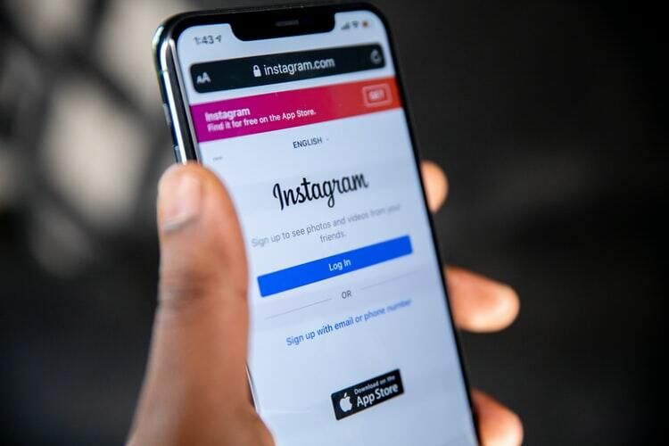 Een hand houdt een telefoon vast met de inlogpagina van Instagram op het scherm
