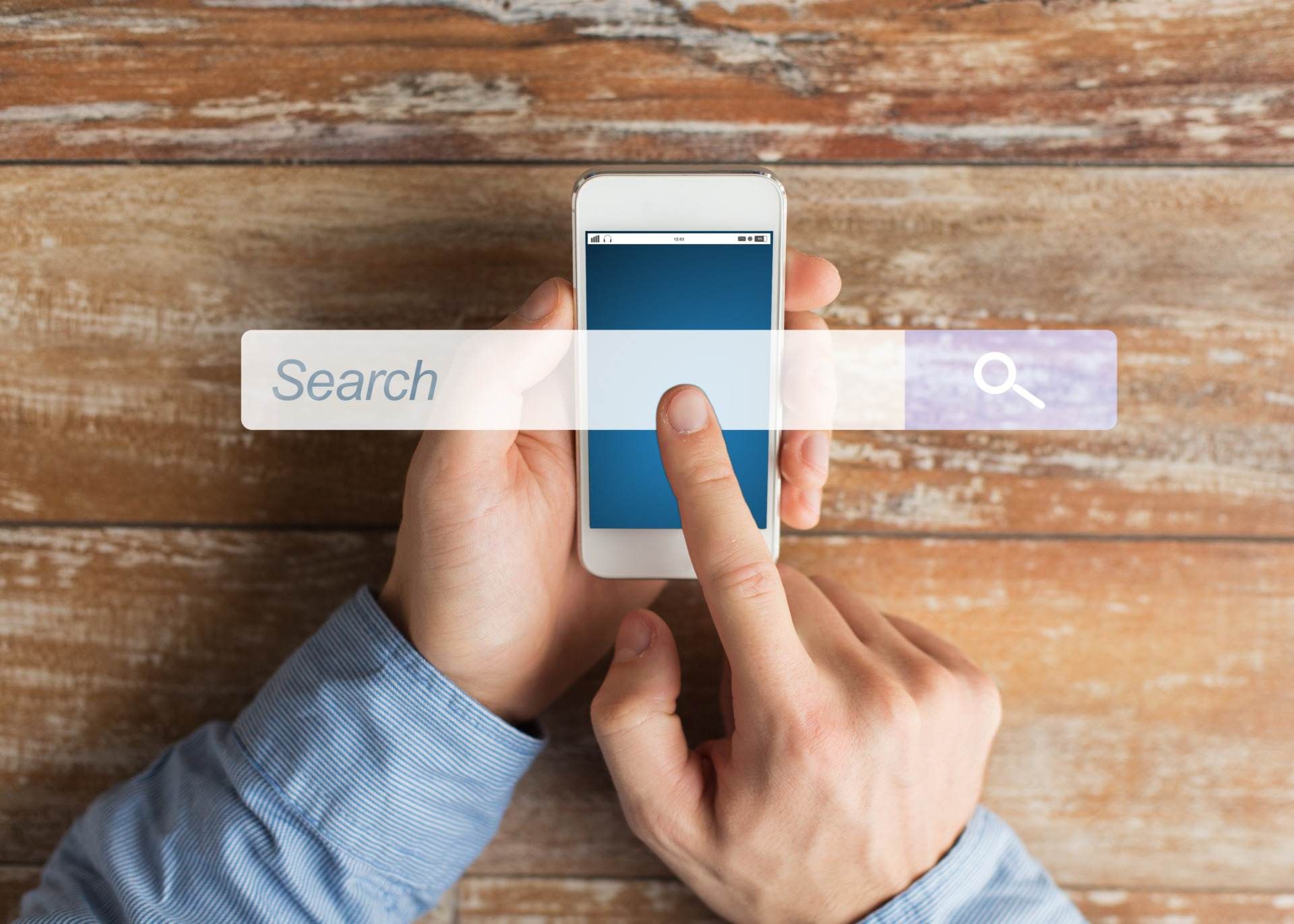 Twee handen bedienen een telefoon, met daaroverheen een zoekbalk met het woord Search en een vergrootglas