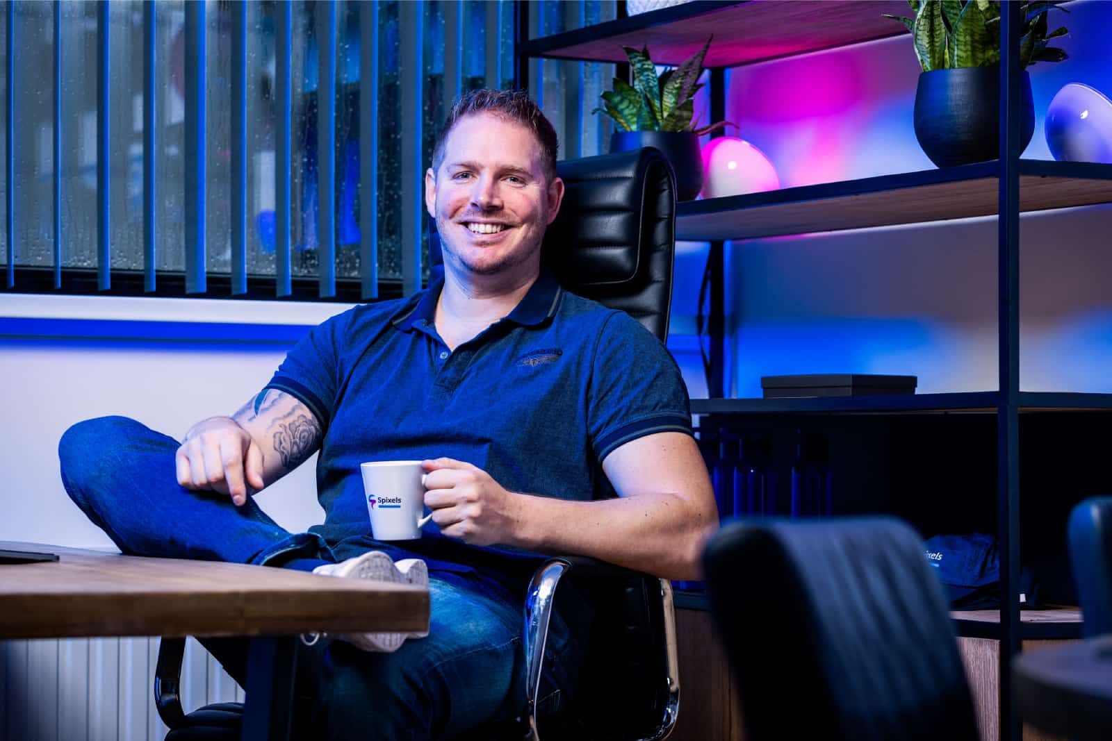 Sven Kersten zit ontspannen achterover in zijn kantoor met een Spixels-mok in zijn hand